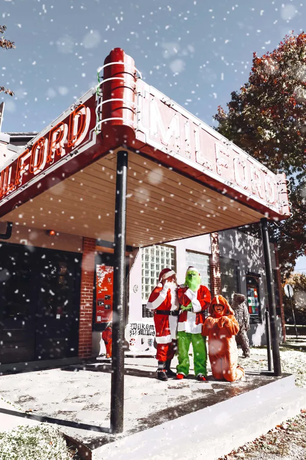 two people dressed as santa clause standing in front of a store