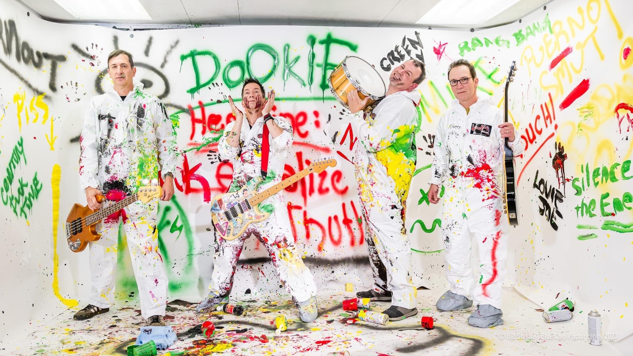a group of people standing in front of a wall covered in graffiti