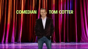 a man standing in front of a red curtain