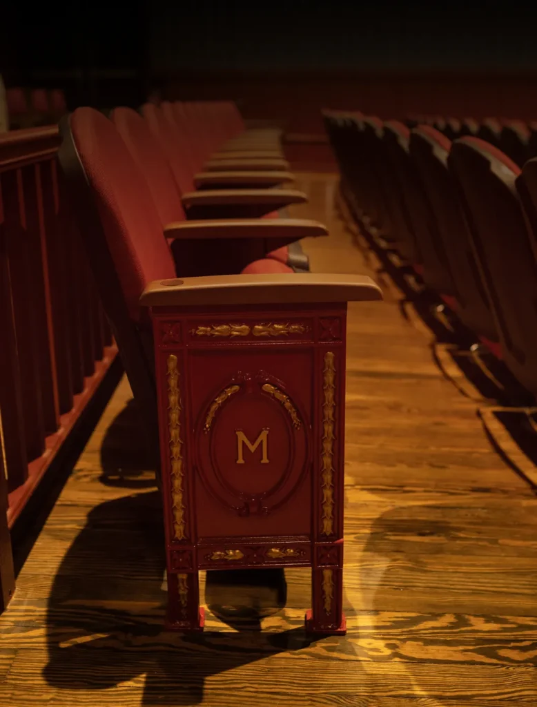 a row of red chairs sitting on top of a wooden floor