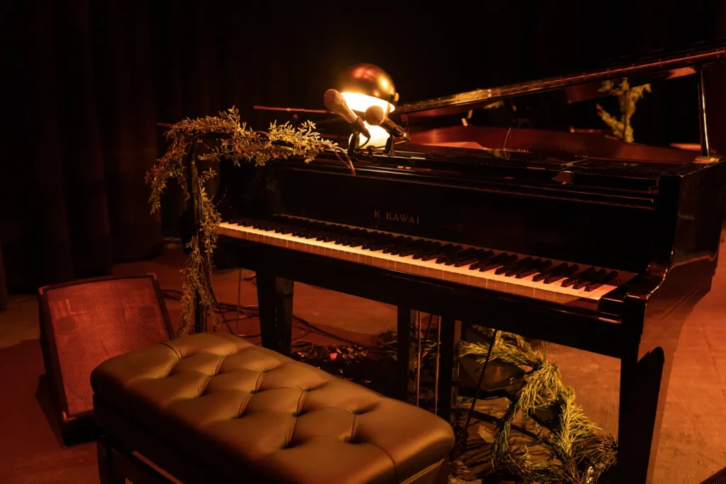 a piano and a stool in a dark room